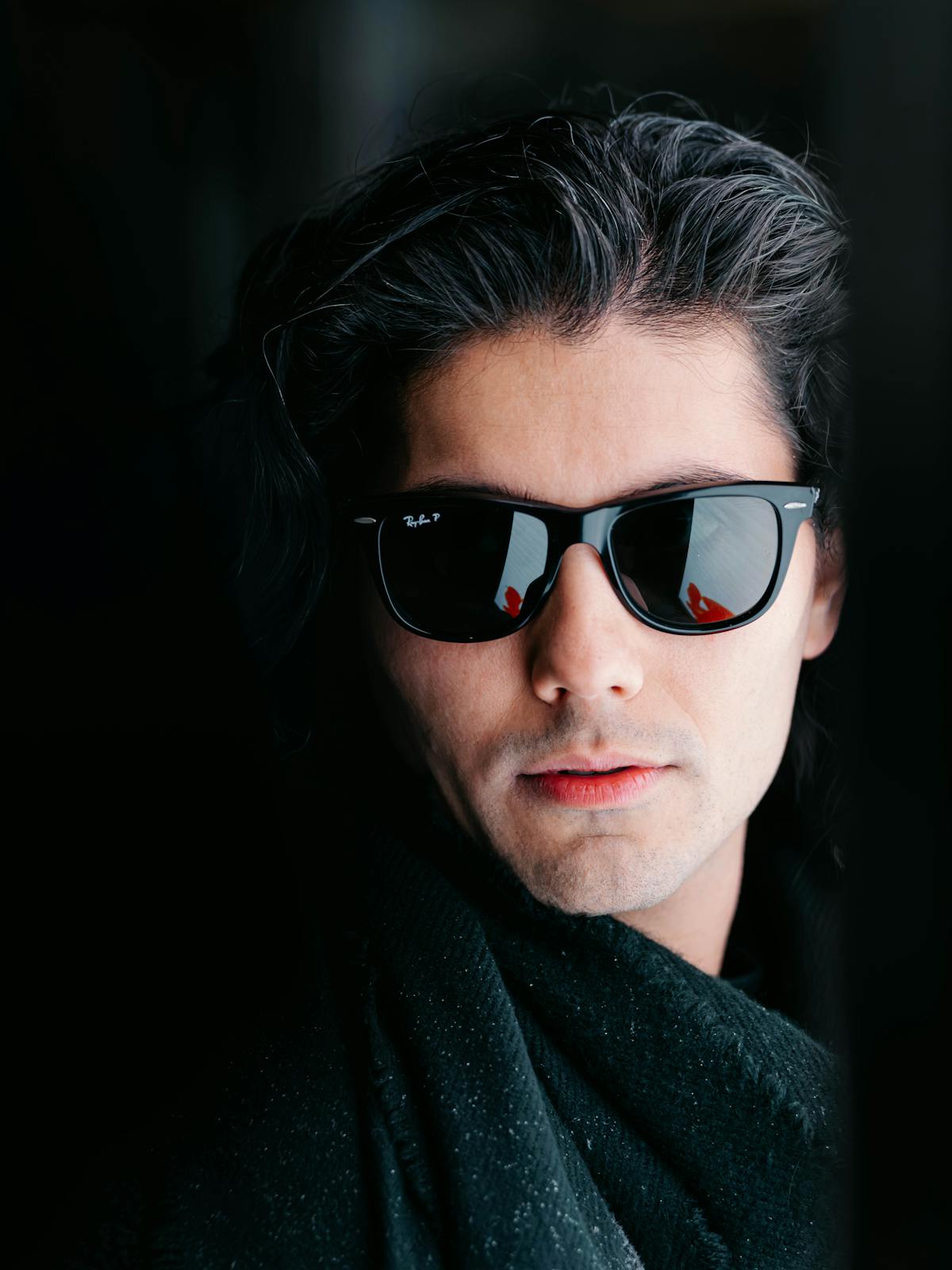 Hanno Fischer outdoors in his trademark dark sunglasses, the collar of a black coat just visible.