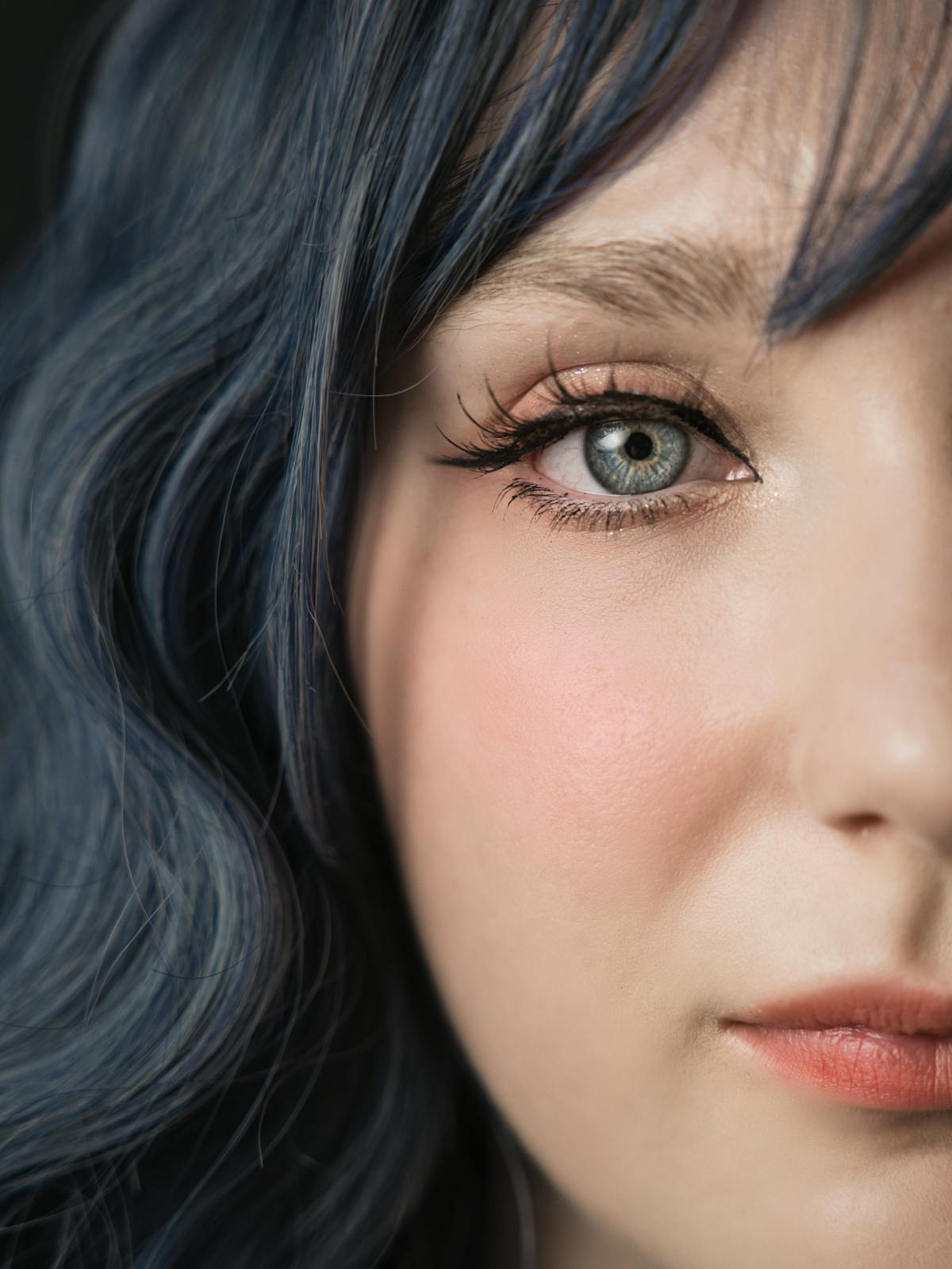 June Halberg in a tight close-up portrait, soft blue-toned hair catching the light.