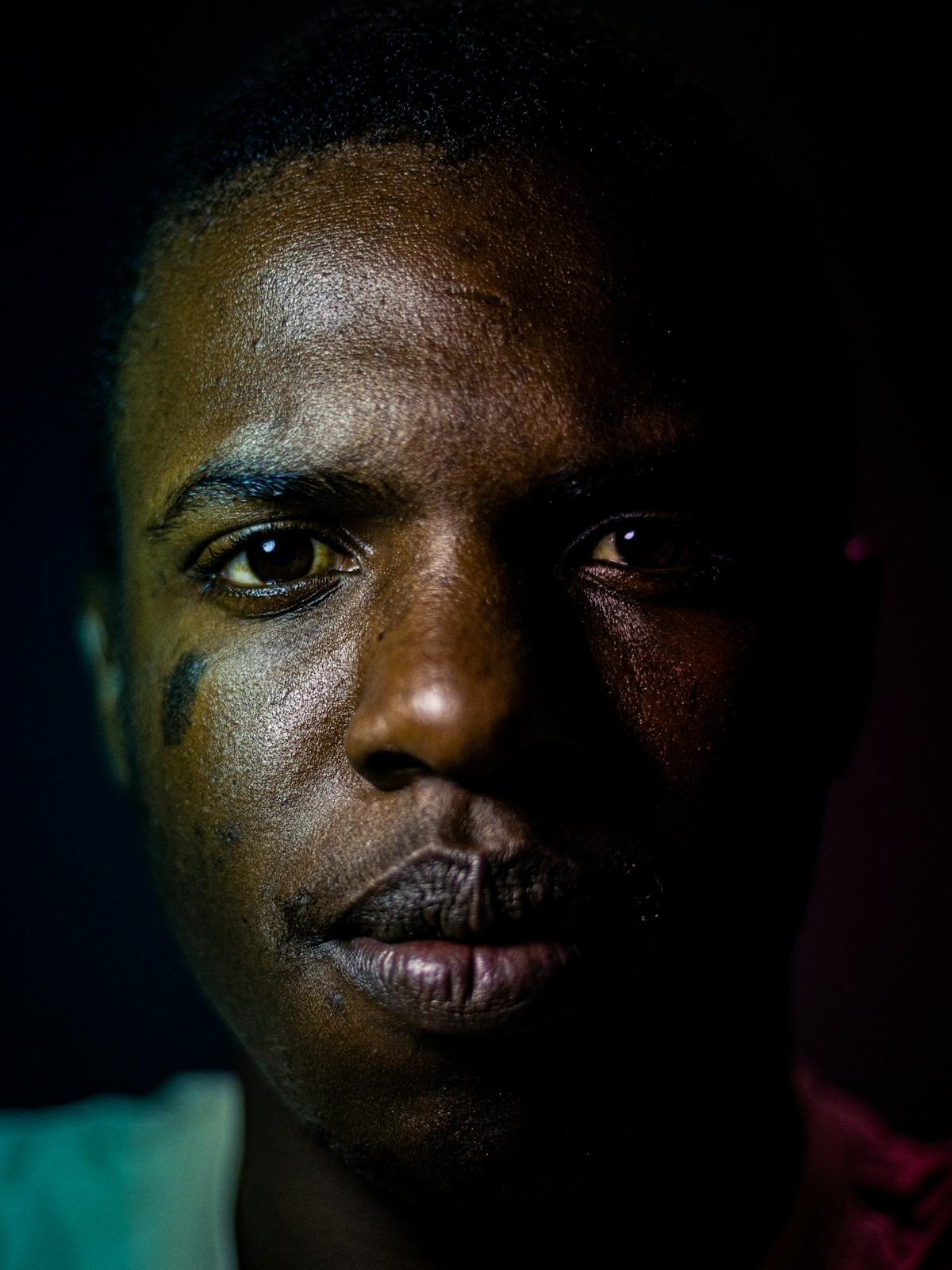 Mathieu Berge in dramatic side-lit portrait, considering the camera.